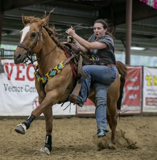 A Next Level rider stepping off her horse at full speed
